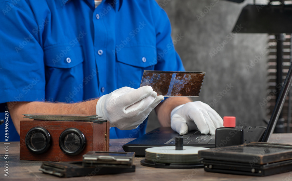 technician with white gloves digitizing old photography on glass plate technician with white gloves digitizing old photography on glass plate