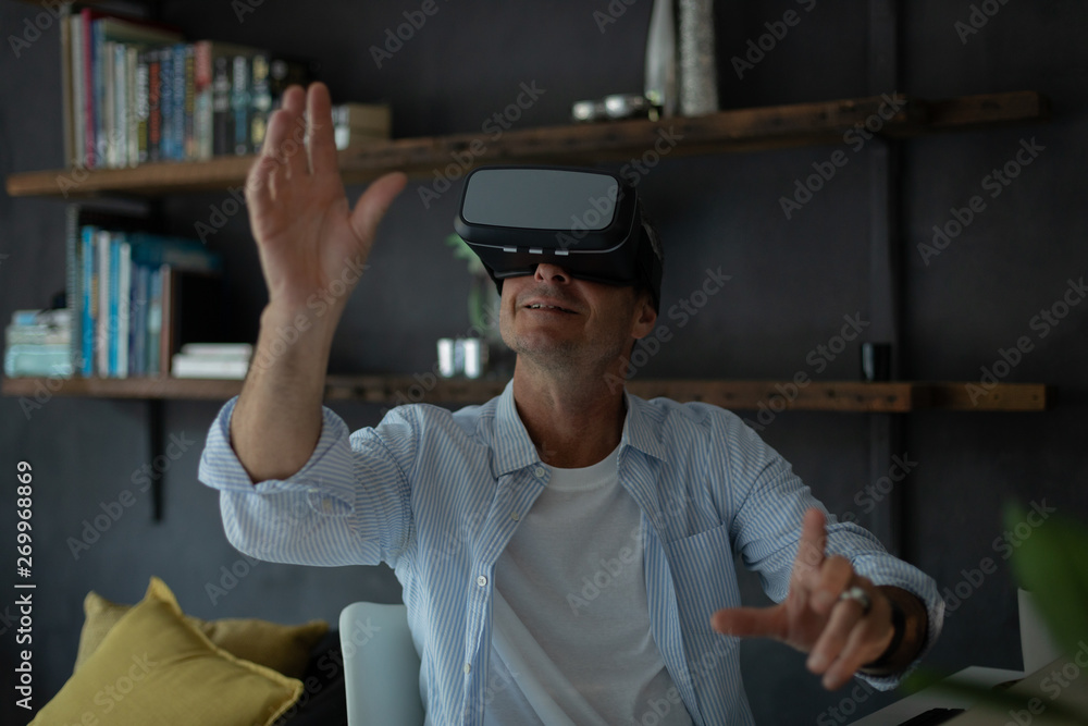 Mature man using virtual reality headset in living room Mature man using virtual reality headset in living room