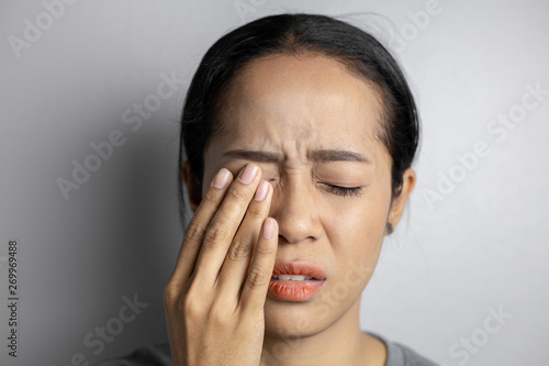 Woman suffering from strong eye pain.