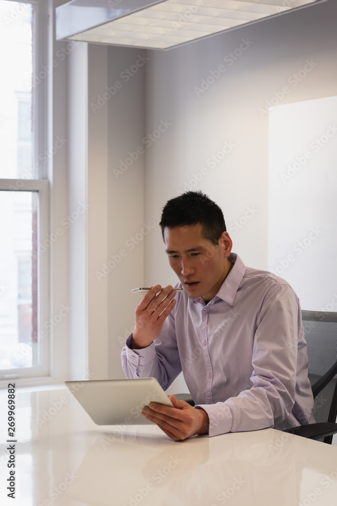 Businessman using digital tablet while talking on mobile phone Businessman using digital tablet while talking on mobile phone