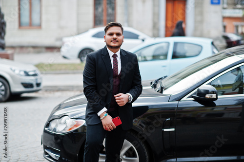 Wallpaper Mural Stylish indian businessman in formal wear with mobile phone standing against black business car on street of city. Torontodigital.ca