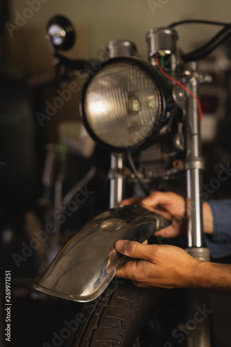 Bike mechanic fixing mudguard of bike 