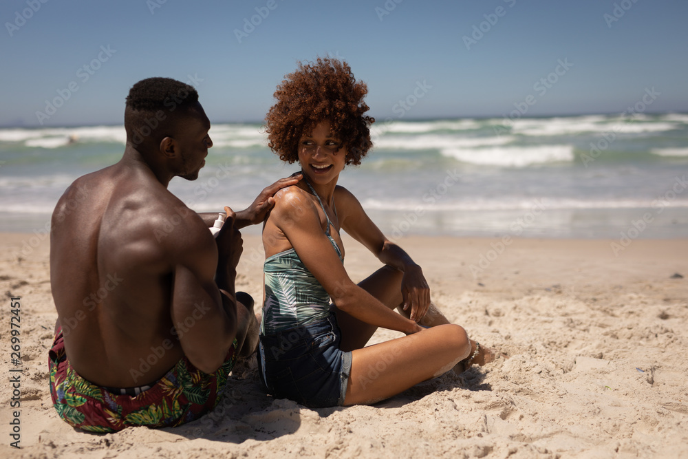 Man applying sunscreen lotion on womans body at beach Stock-Foto | Adobe  Stock