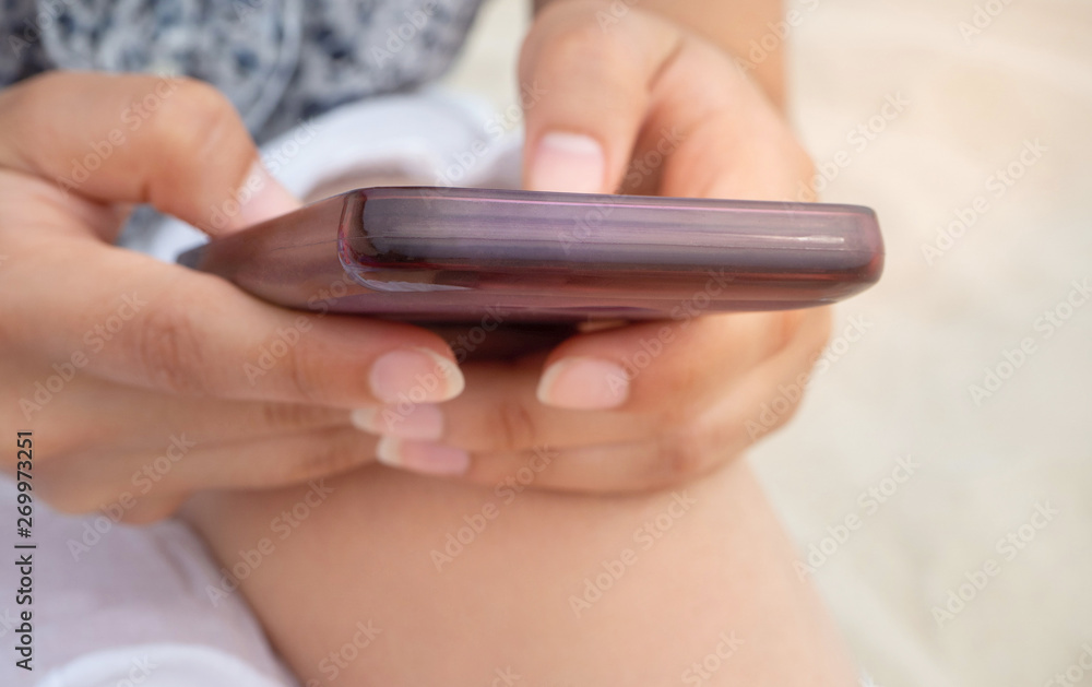Close-up of woman using mobile phone on the beach. technology and summer concept Close-up of woman using mobile phone on the beach. technology and summer concept
