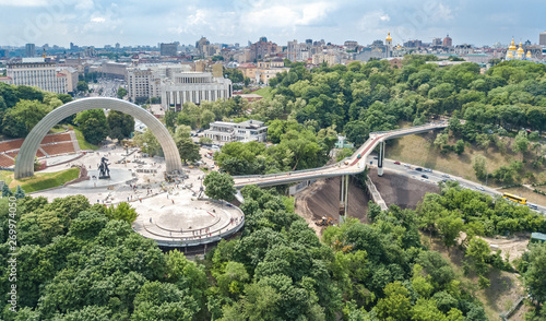Aerial drone view of new pedestrian cycling park bridge construction, hills, parks and Kyiv cityscape from above, city of Kiev skyline, Ukraine