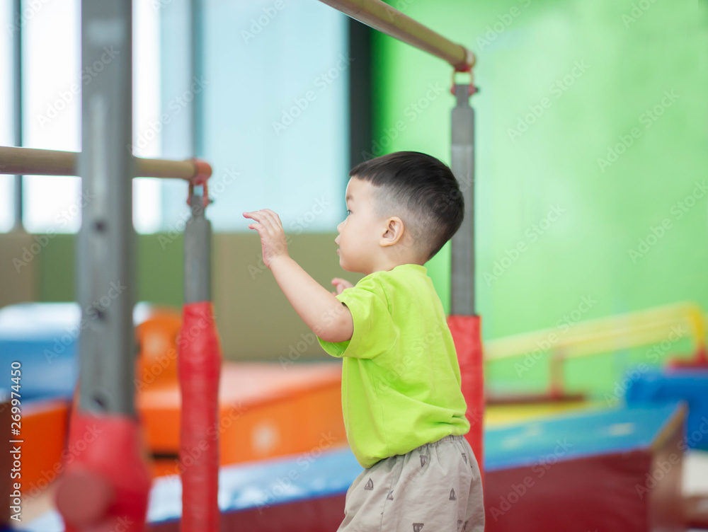 Little toddler boy working out at the indoor gym excercise Little toddler boy working out at the indoor gym excercise