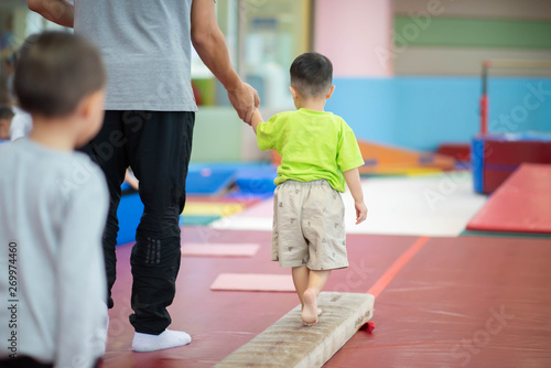 Little toddler boy working out at the indoor gym excercise