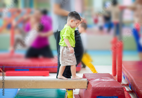 Little toddler boy working out at the indoor gym excercise