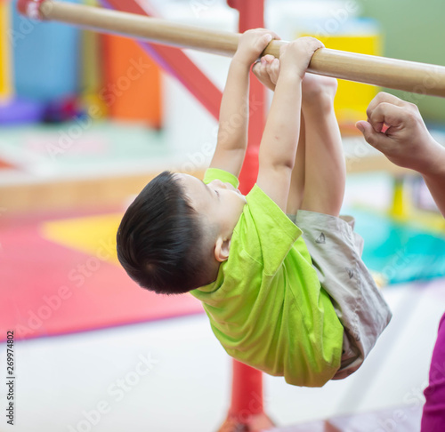 Little toddler boy working out at the indoor gym excercise