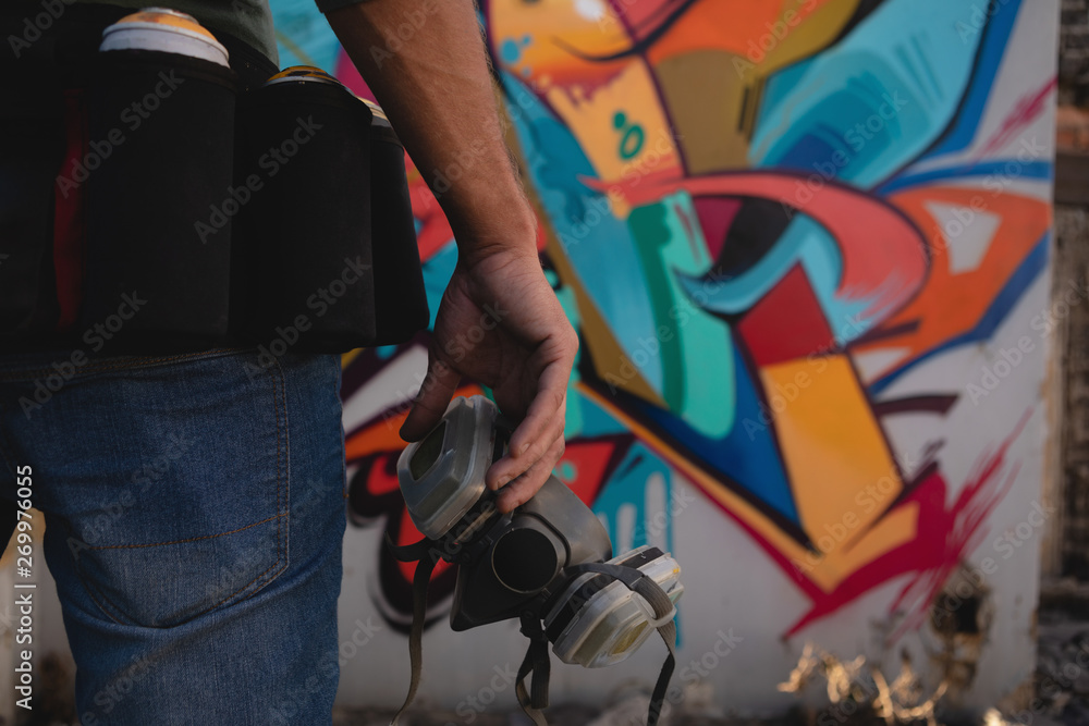 Man holding protective mask while walking from alley