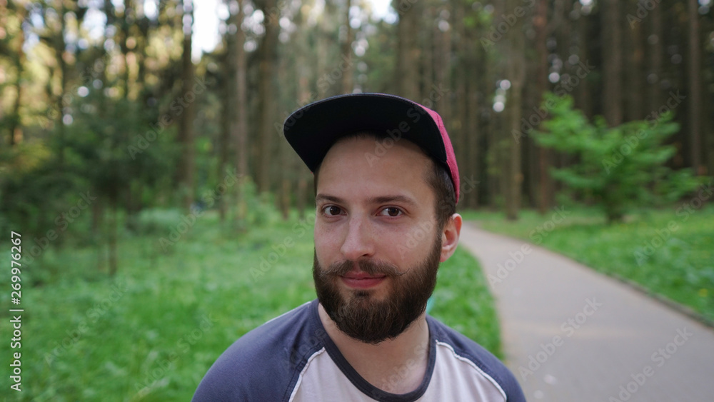 Portrait of smiling brutal bearded hipster man in the forest   and he has a great chic mustache
