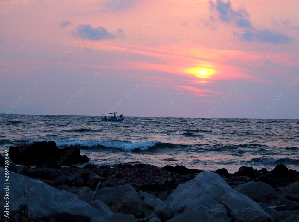 evocative image of fishing boats at sunset