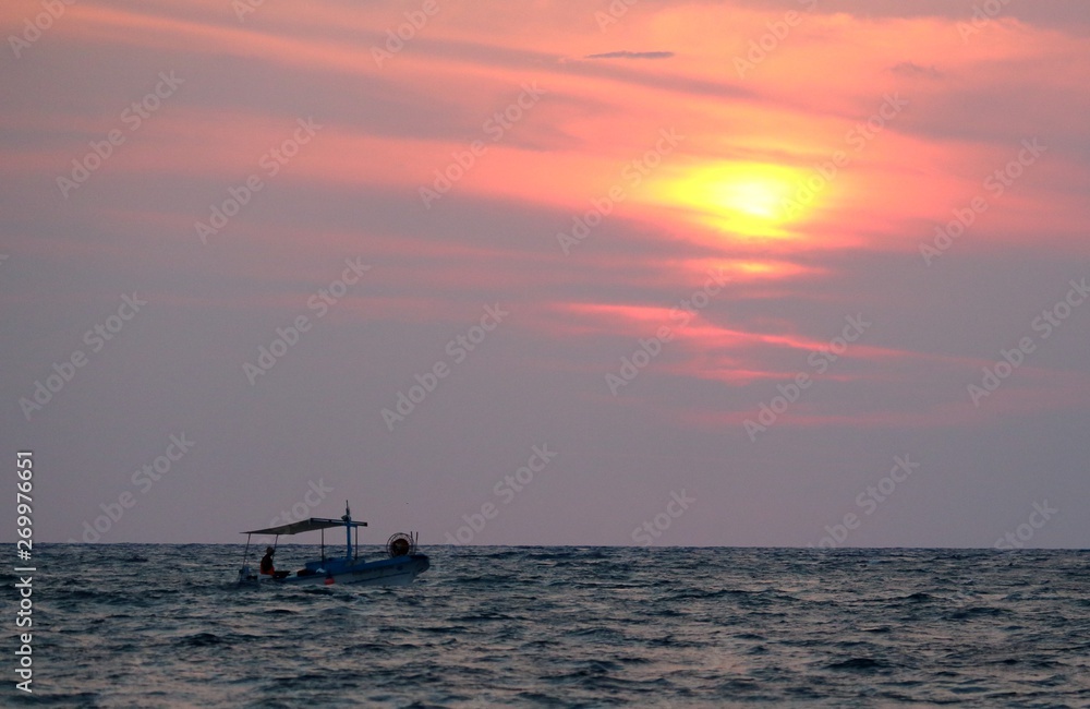 evocative image of fishing boats at sunset