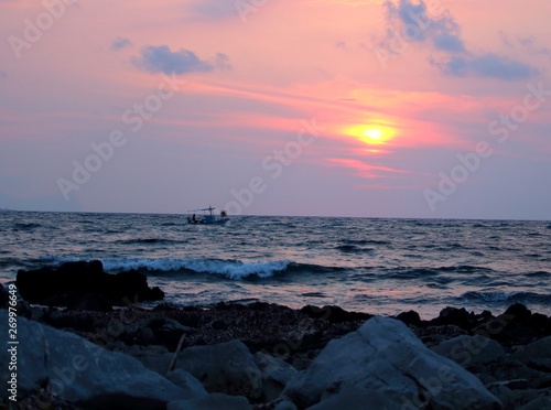 evocative image of fishing boats at sunset