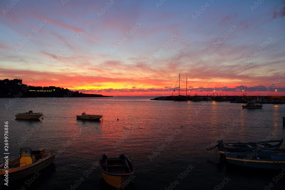 evocative image of fishing boats at sunset in port
