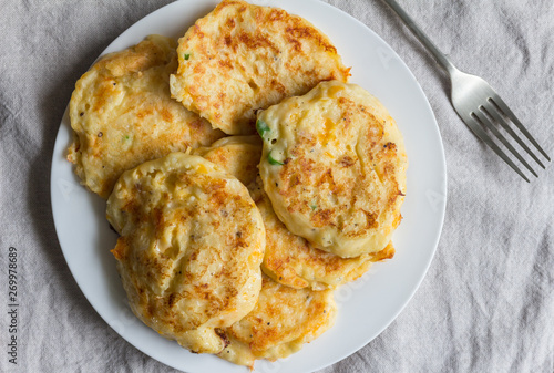 Potato cakes heaped on white plate with serving fork
