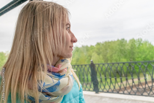 beautiful young blond woman rides the bus and looks out the window