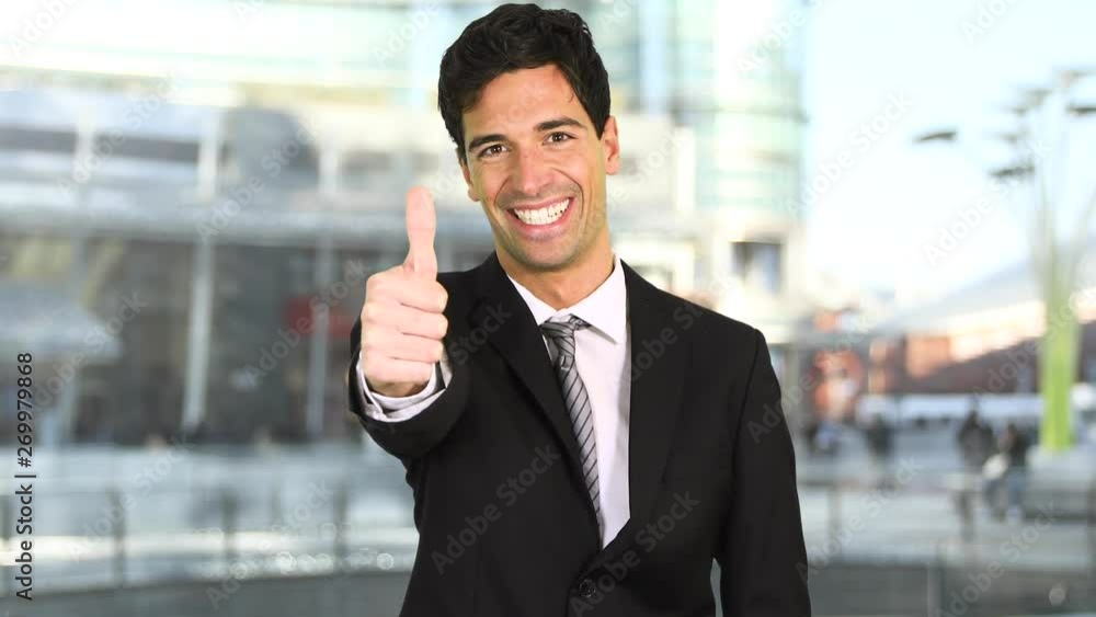 Smiling young businessman showing thumbs up Smiling young businessman showing thumbs up