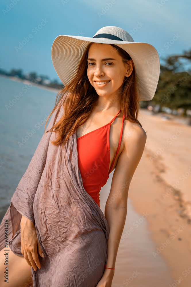 Beautiful woman with red swimsuit on the beach in Summer 
