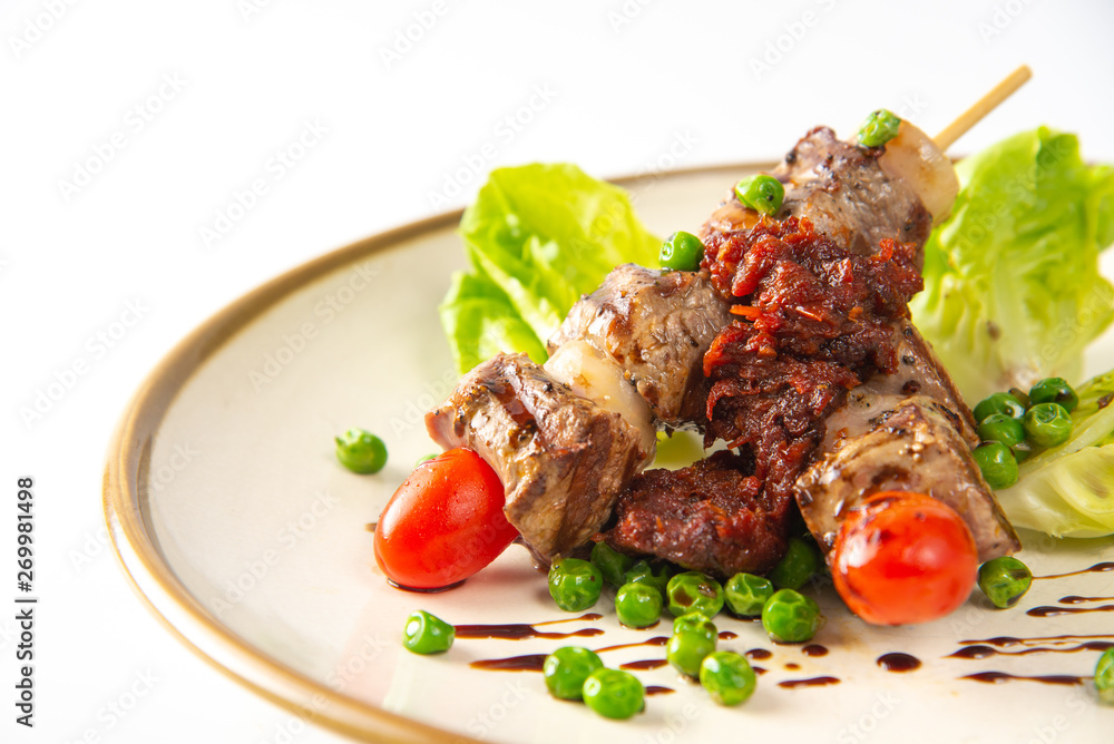 grilled meat and vegetables on plate isolated on white