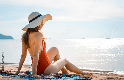 Beautiful woman with red swimsuit on the beach in Summer 