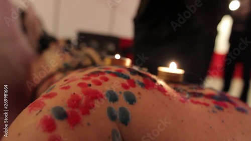 the girl is bent from pain and pleasure at the moment when drops of wax are dripping on her back photo