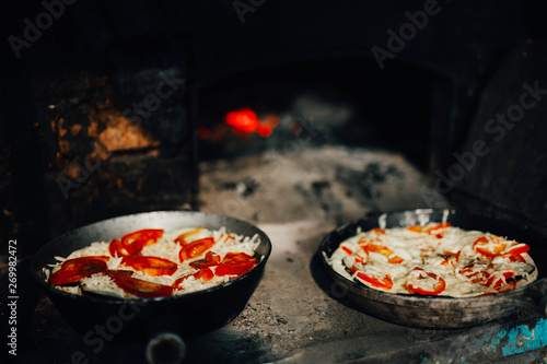 rustic pizza with tomatoes and ketchup in the oven