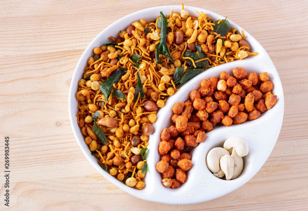 South indian spicy crunchy mix Nimco or Namkeen and spicy coated peanut white bowl wooden background isolated. South indian spicy crunchy mix Nimco or Namkeen and spicy coated peanut white bowl wooden background isolated.