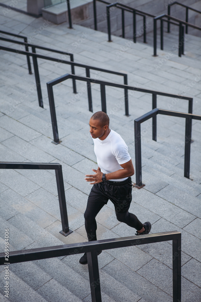 Portrait of sportsman running up stairs