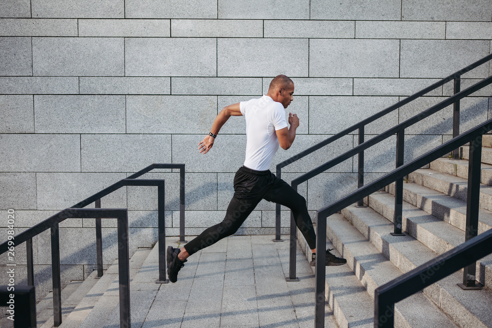 Portrait of sportsman running up stairs