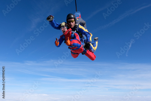 Skydiving. Tandem jump. Girl and man are in the sky together.