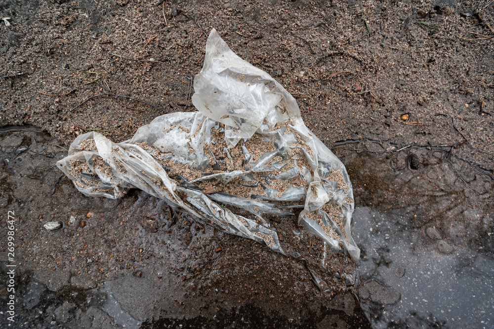White plastic bag on the road in the mud White plastic bag on the road in the mud