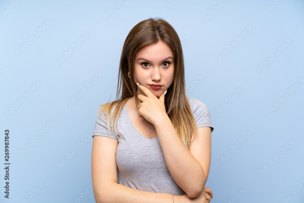 Teenager girl over isolated blue wall thinking Teenager girl over isolated blue wall thinking