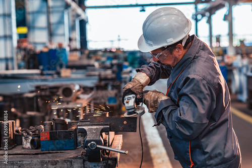 Fotografia Skilled industrial worker grinding metal part.