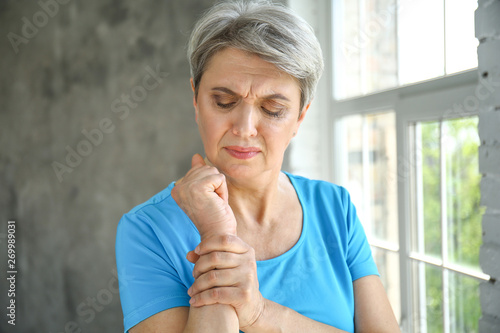 Mature woman suffering from pain in wrist at home