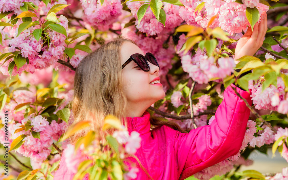 summer holiday. Childhood beauty. skincare. Natural cosmetics for skin. blossom smell, allergy. small girl in spring flower bloom. happy girl in cherry flower. Sakura tree blooming. Summer happiness