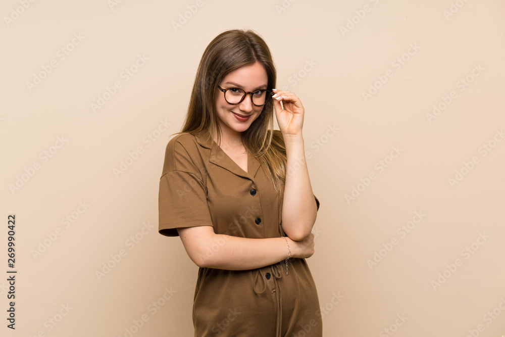 Teenager girl over isolated background with glasses and smiling