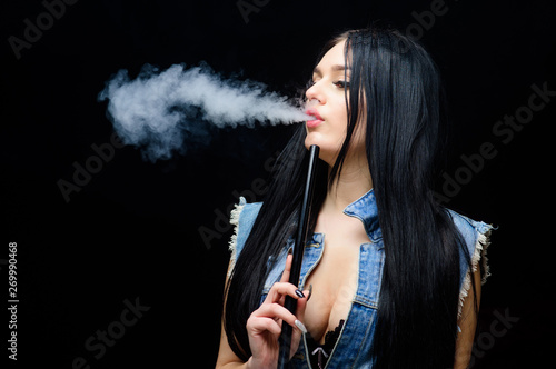 White cloud of smoke. Vaping is sexy. Nicotine addiction. Glamorous brunette smoking vaping device black background. Girl vaping. Rest and relax. Hookah bar. Electronic cigarette. Fashion girl vaping