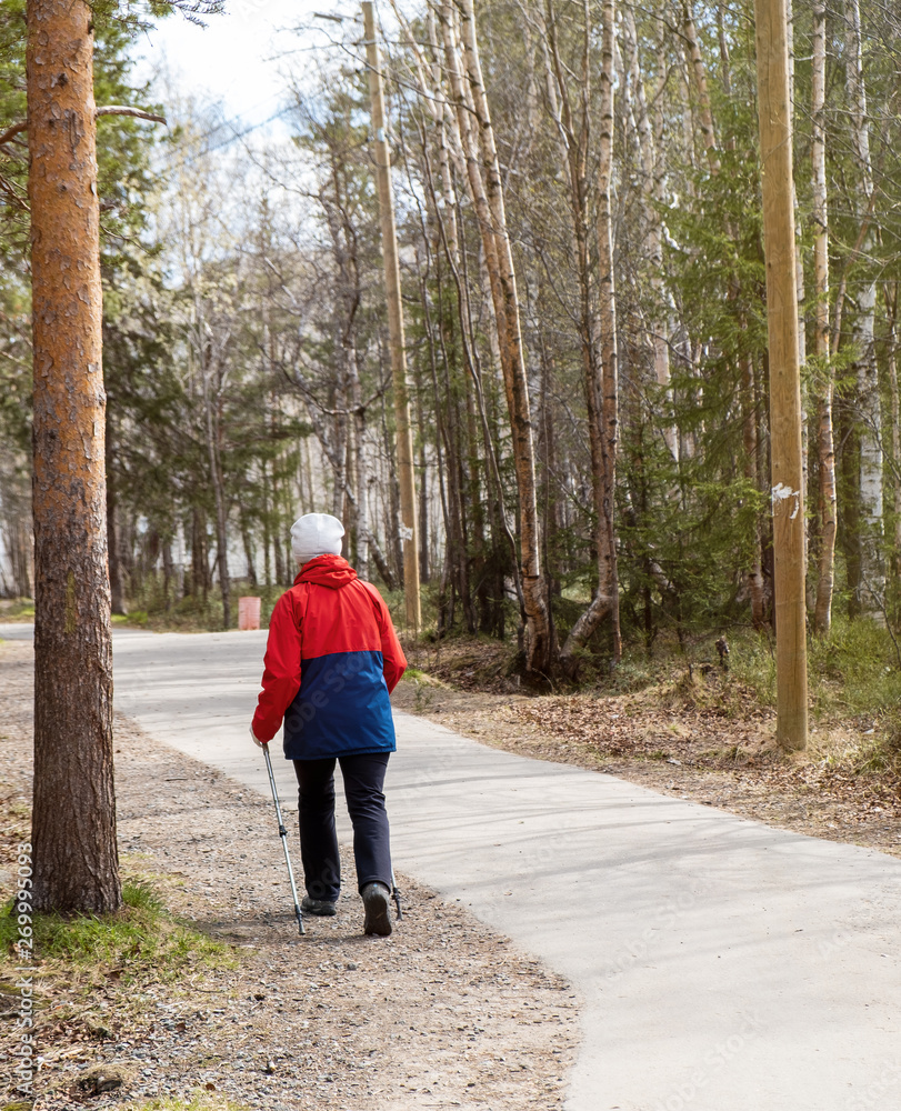Nordic walking. Woman hiking in the forest or park. Active and healthy lifestyle Nordic walking. Woman hiking in the forest or park. Active and healthy lifestyle