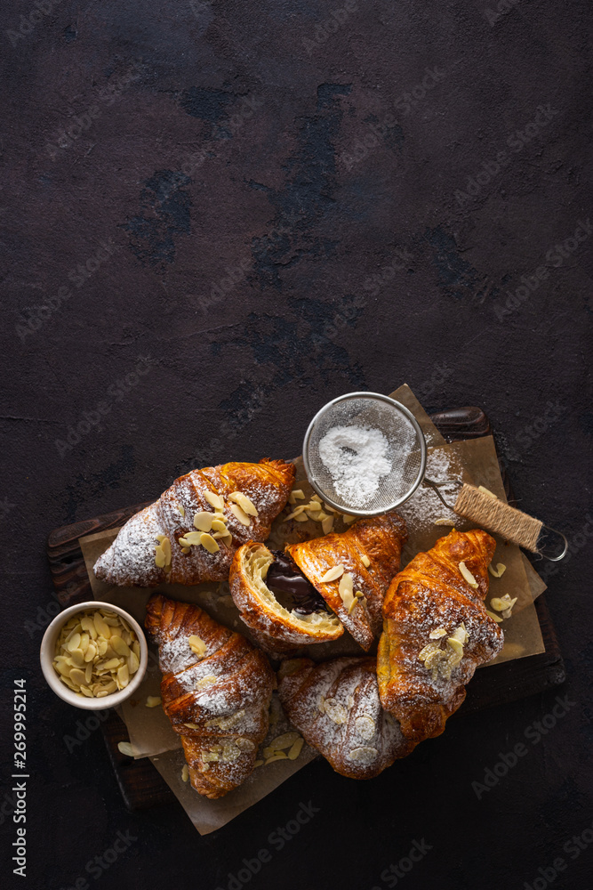 Vegan croissants with almond flakes and icing sugar top view copy space