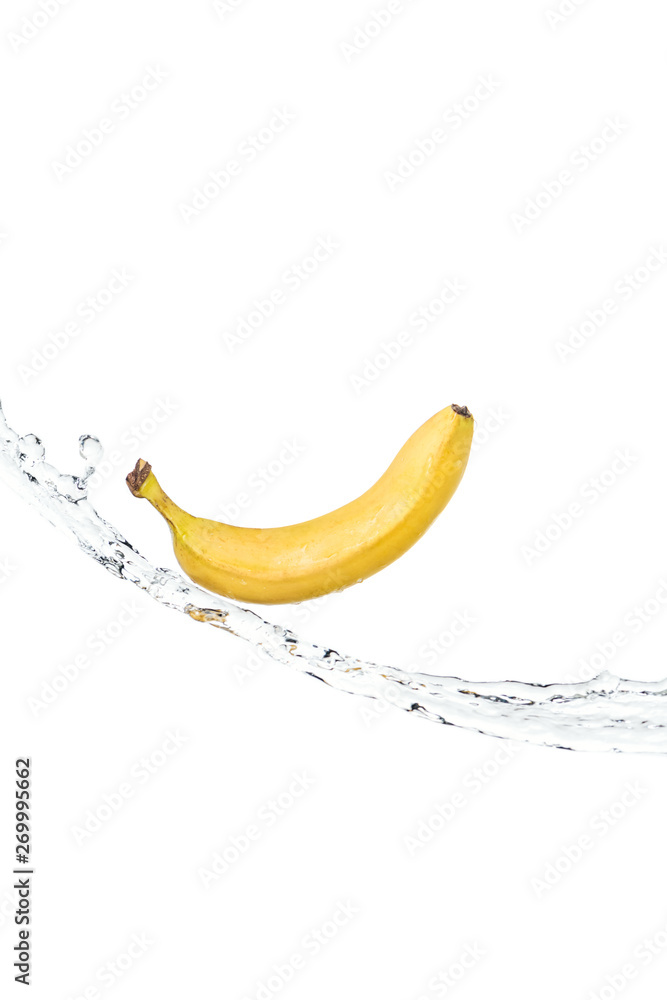 whole ripe yellow banana on water stream isolated on white