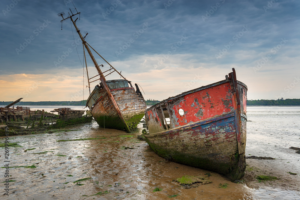 Old boat wrecks under a stormy sky