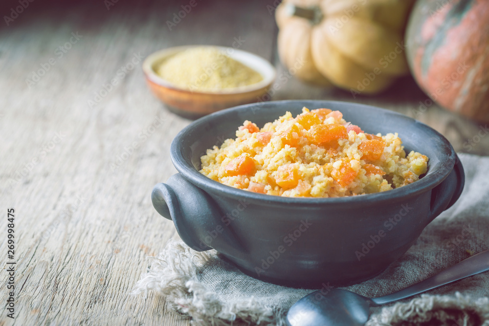 Millet porridge with sweet pumpkin in a bowl, rustic style. Healthy vegan dish. Millet porridge with sweet pumpkin in a bowl, rustic style. Healthy vegan dish.