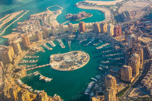 Rich real estate Pearl-Qatar island in Doha through the airplane porthole, aerial view photo