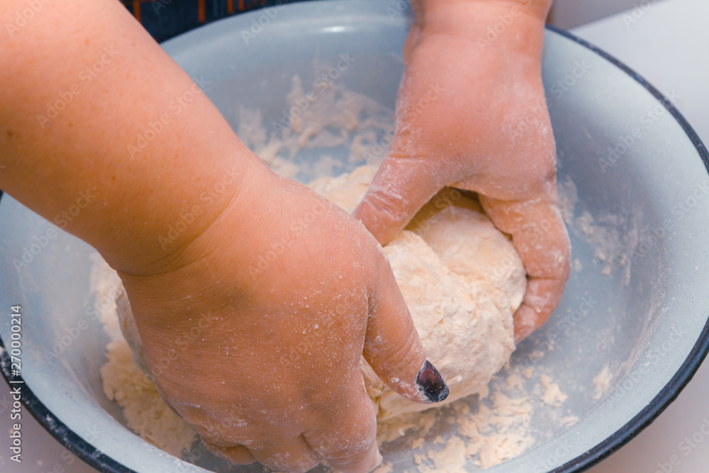 Fototapeta premium Mix the dough with your hands in a bowl