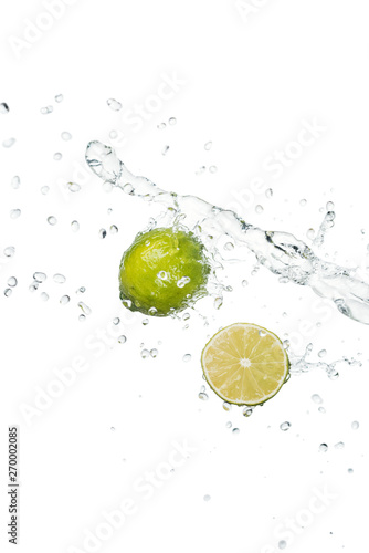 green fresh whole lime and half with clear water splash and drops isolated on white