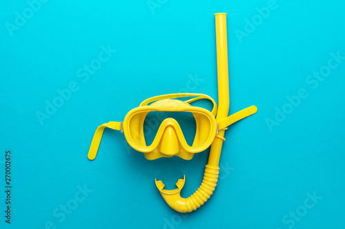 Photo flat lay shot of yellow diving mask with snorkel over turquoise blue background