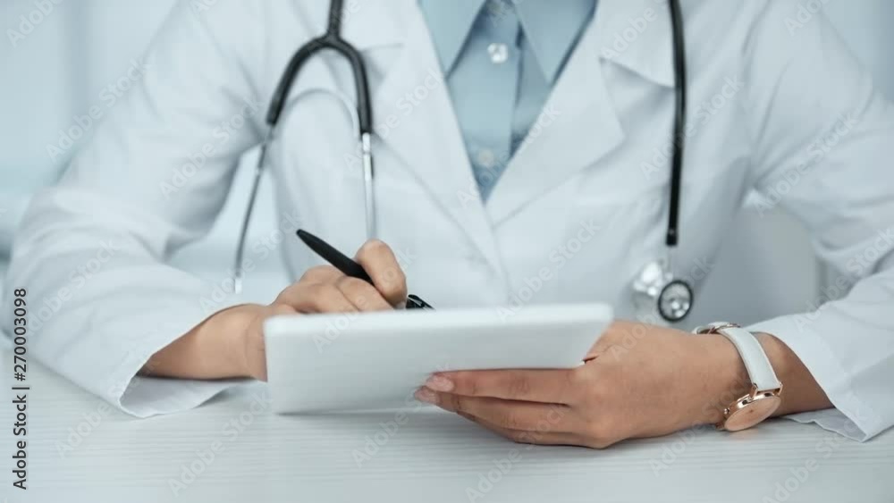 cropped view of doctor with stethoscope using digital tablet at workplace cropped view of doctor with stethoscope using digital tablet at workplace