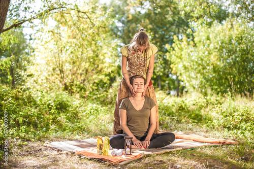 Woman masseuse applies her massage skills on her client in nature. photo