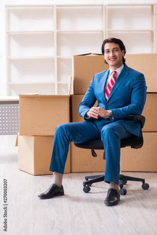 Young handsome businessman moving to new workplace Young handsome businessman moving to new workplace
